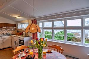 a kitchen with a table with flowers on it at Finest Retreats - Lewcott in Sennen