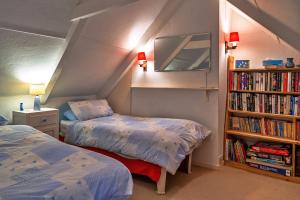 a bedroom with two beds and a book shelf at Finest Retreats - Lewcott in Sennen