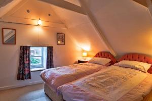 1 dormitorio con 2 camas y ventana en Finest Retreats - Lewcott, en Sennen