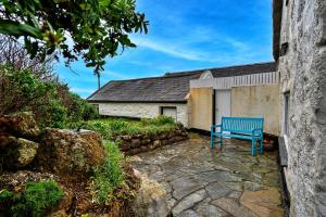 um banco azul sentado em frente a um edifício em Finest Retreats - Lewcott em Sennen