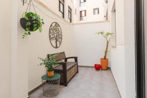 a small balcony with a bench and potted plants at Malagaflat City Center in Málaga