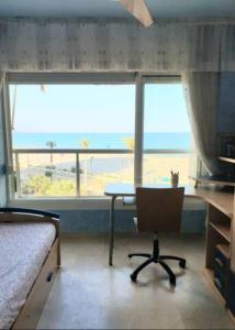 een slaapkamer met een bureau en een stoel voor een raam bij Magnifico apartamento en primera linea de Playa in El Campello