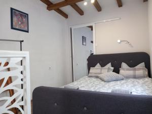 a bedroom with a bed with a black headboard and pillows at Charming studio in the city center in Plovdiv