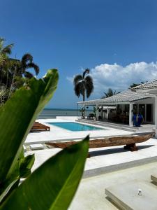 a swimming pool with a house and the ocean at Villa Teri in Lipa Noi