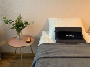 uma cama com um vaso de flores e uma vela sobre uma mesa em Cozy Two Room Apartment near city centre em Alytus