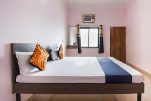 a bedroom with a bed with orange and blue pillows at OYO Hotel Kanyaratna And Lodging in Chas