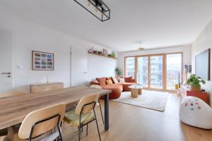 uma sala de estar com uma grande mesa de madeira e cadeiras em Résidor - Sublime Bright Apartment em Asnières-sur-Seine