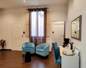 ein Wohnzimmer mit 2 blauen Stühlen und einem Tisch in der Unterkunft Residenza San Lorenzo Firenze in Florenz