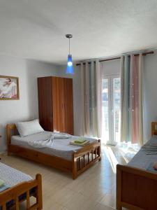 a bedroom with two beds and a window at Eiffel's Guest House in Pogradec