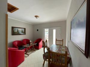 a living room with red chairs and a table at Eiffel's Guest House in Pogradec