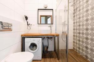 a bathroom with a washing machine and a sink at Golden Apartments Wroclaw&K28 in Wrocław
