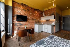a kitchen with a brick wall and a table in a room at Golden Apartments Wroclaw&K28 in Wrocław