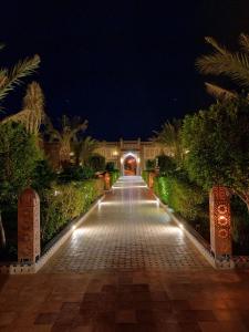 a walkway leading to a building at night at Kasbah Yasmina Hotel in Lac Yasmins