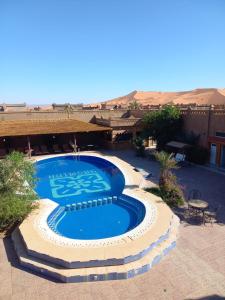 a large swimming pool in the middle of a desert at Kasbah Yasmina Hotel in Lac Yasmins