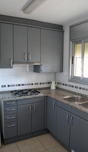 eine Küche mit grauen Schränken und einer Spüle in der Unterkunft Luz Marina in Torredembarra