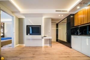 a living room with a tv and a kitchen at My Story Sopot Apartments in Sopot