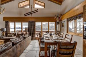 a dining room with a long table and a couch at Chalet Coeur in La Tzoumaz