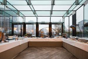 a restaurant with a large glass ceiling and a table at Montcalm Royal London House, London City in London +37 photos