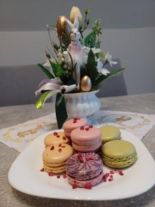 a plate of cookies on a table with a vase of flowers at Vár-Lak Apartman in Sümeg
