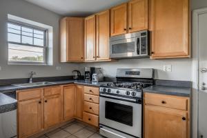 - une cuisine avec des placards en bois, une cuisinière et un four micro-ondes dans l'établissement Evanston 1br w courtyard nr beach university CHI-952, à Evanston