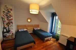 Zimmer mit 2 Betten und einer Bank in der Unterkunft Maison à la campagne proche Disney in Couilly-Pont-aux-Dames