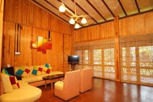 a living room with a couch and chairs and a tv at Lake Resort Bolgoda in Wadduwa