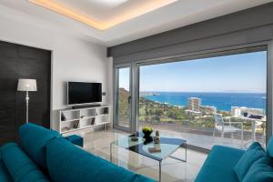 a living room with a blue couch and a large window at Rhodes Skyline Suite with out Door Jacuzzi Sea View A2 in Ixia