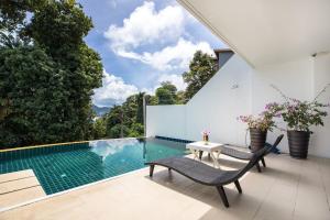 una piscina en una casa con 2 sillas y una mesa en Private 3-Storey Pool Villa Atika 10, for 7, views of Patong Bay en Patong