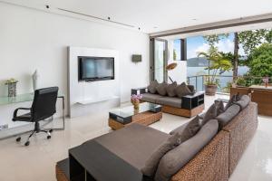 a living room with a large couch and a television at Private 3-Storey Pool Villa Atika 10, for 7, views of Patong Bay in Patong Beach