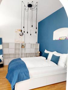ein Schlafzimmer mit einem weißen Bett und einer blauen Wand in der Unterkunft Vienna Charm Apartment in Wien