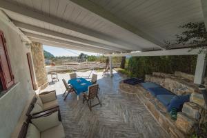 un patio al aire libre con una mesa azul y sillas en Dea Rooms, en Castellabate
