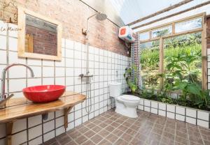 a bathroom with a red sink and a toilet at La Maison House & Bungalow in Sa Pa