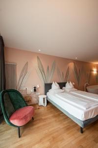 sypialnia z dużym łóżkiem i krzesłem w obiekcie Boutique Hotel Imperialart w Meranie