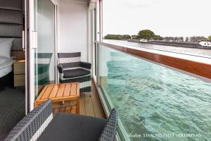 a balcony with a view of the water on a ship at KD Moment Premium Hotelship Köln in Cologne