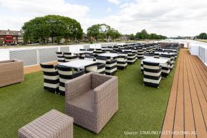 a row of tables and chairs on a roof at KD Moment Premium Hotelship Köln in Cologne