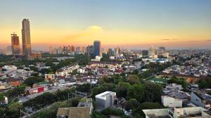 Blick auf eine Stadt bei Sonnenuntergang mit hohen Gebäuden in der Unterkunft Studio Apartment JiExpo Kemayoran Sunrise View -Min Stay 3 nights- in Jakarta