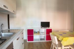 a kitchen with a table and a tv on a counter at BOLINA e FIOCCO in Follonica