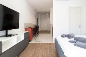 a bedroom with a bed and a flat screen tv at Dimora Trecuori in Naples
