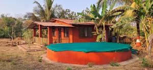 una pequeña casa con una gran bañera frente a ella en Arpita FarmStay, en Malvan