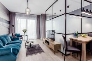 a living room with a blue couch and a table at DEO PLAZA - Apartments at the Old Town in Gdańsk
