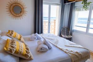 a bedroom with a bed with towels and a window at HOTEL RESTAURANT LA COTE REVEE in Leucate