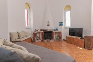 Una sala de estar con chimenea y televisión. en Dea Rooms, en Castellabate