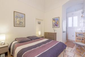 a bedroom with a bed and a desk and a window at Le Napoléon - Appt à moins dun km de la plage in LʼÎle-Rousse +6 photos