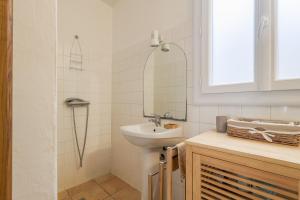 La salle de bains est pourvue d'un lavabo et d'une douche. dans l'établissement Le Napoléon - Appt à moins dun km de la plage, à LʼÎle-Rousse