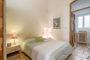 a bedroom with a bed and a window at Le Napoléon - Appt à moins dun km de la plage in LʼÎle-Rousse