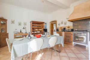 une salle à manger avec une table et des chaises dans une cuisine dans l'établissement Le Napoléon - Appt à moins dun km de la plage, à LʼÎle-Rousse