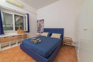 ein Schlafzimmer mit einem blauen Bett und einem Fenster in der Unterkunft Villetta relax in Castellabate