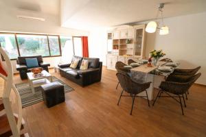 Una sala de estar con un sofá y una mesa con sillas. en Casa Moura Golfe, en Vilamoura