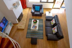 einen Blick über ein Wohnzimmer mit Sofa und Stühlen in der Unterkunft Casa Moura Golfe in Vilamoura