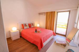 Un dormitorio con una cama roja y una ventana. en Casa Moura Golfe, en Vilamoura 15 fotos más